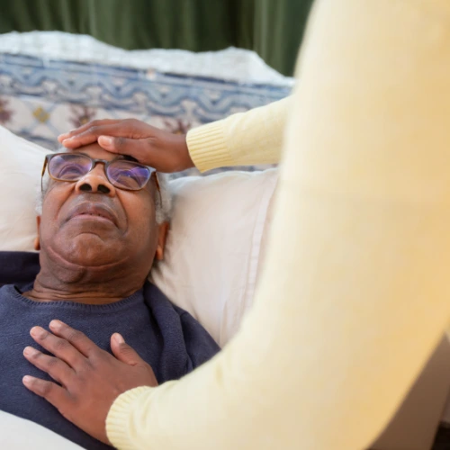 man being comforted by a caregiver in a nursing home