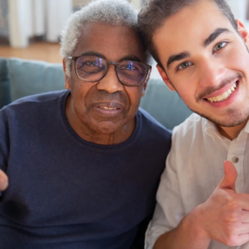 man happy and smiling in a nursing home with a caregiver